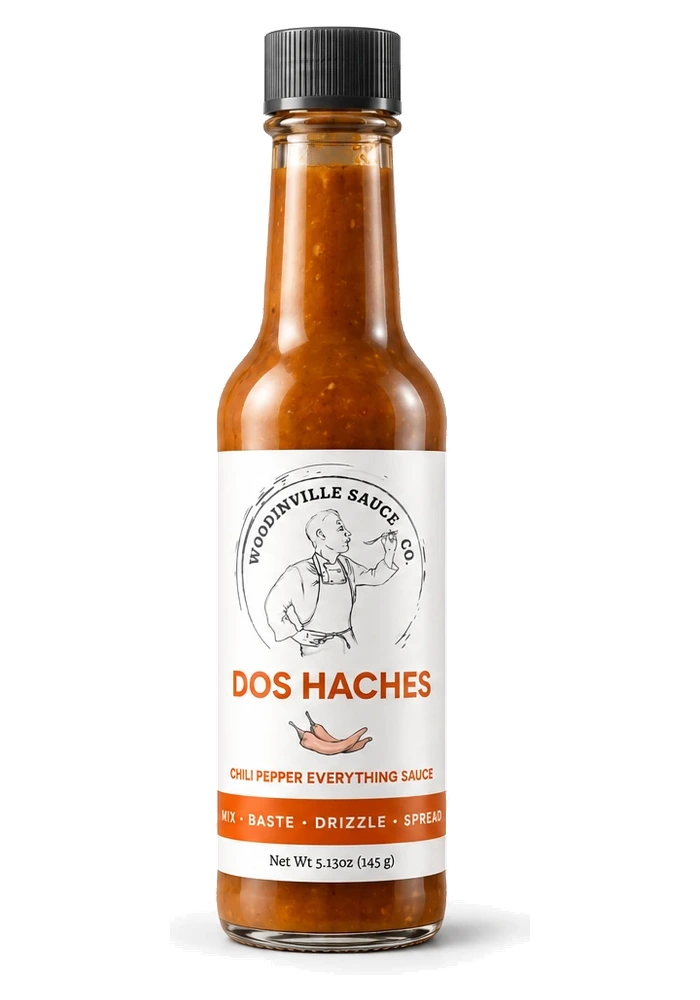 Dos_Haches_standard_web - Woodinville Sauce Co. Bottle of Dos Haches chili pepper everything sauce from Woodville Sauce Co. with a black cap and white label.
