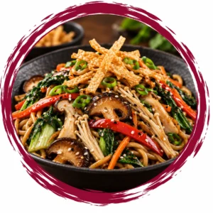 Colorful vegetable noodle stir-fry in a bowl topped with crispy strips, mushrooms, peppers, sesame, and green onions.