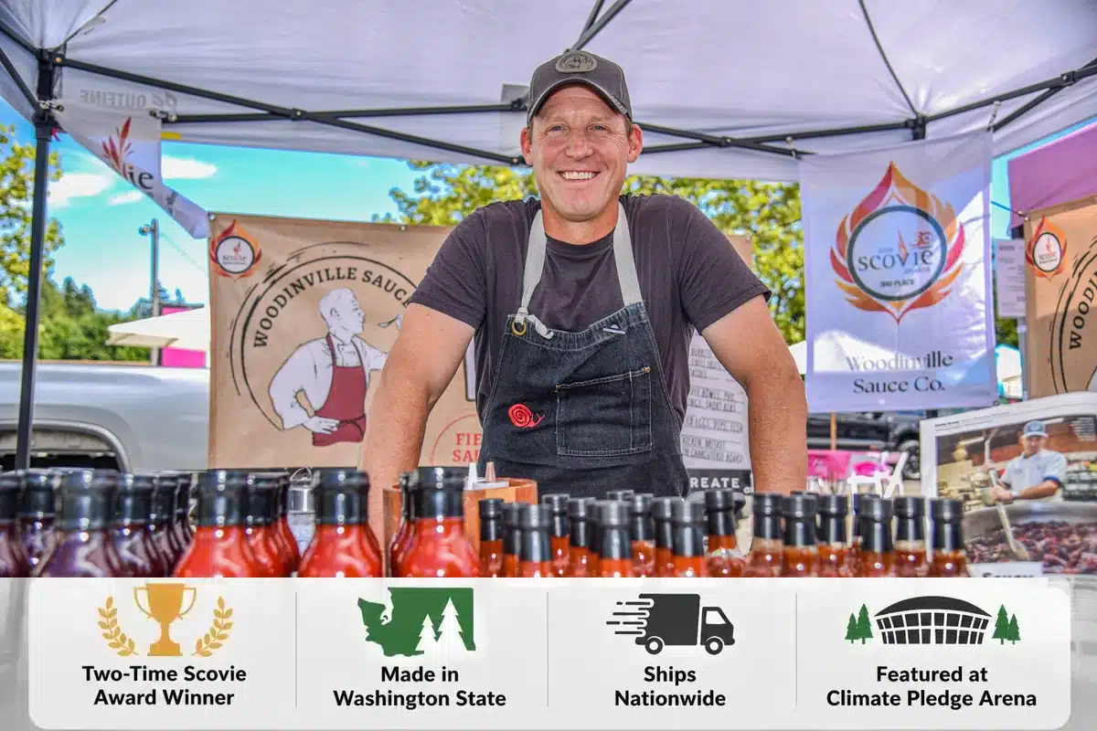 WSC_Homepage_Hero_1200x800 - Woodinville Sauce Co. Smiling Chef Dave in apron behind his sauce in tent